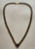 Collier en perles Half Tila noires et rocailles dorées posé à plat, longueur 62 cm et largeur 1 cm